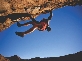 Photograph of a rock climber on a dangerous rock overhang