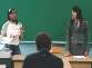 Photograph of two students in front of a classroom having a debate