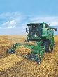 Photograph of farm machinery thrashing wheat in a field