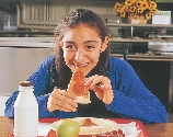 Photograph of a girl (Lupe) eating a slice of pizza