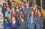 Photograph of a group of students standing by the door of a school bus