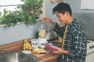 Photograph of a teenage boy about to use a blender