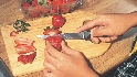 Photograph of a strawberries being sliced with a knife