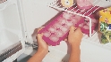 Photograph of someone taking an ice cube tray from a freezer