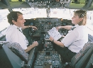 Photograph of two people at the controls of an airplane