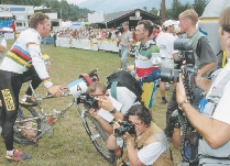 Photographers take pictures at a bicycle race.