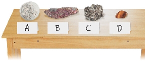 Photograph of four rocks on a table labeled A-D