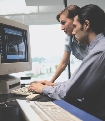 Photograph of two people at a computer