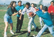 Photograph of teens watching other teens play football