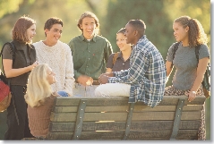 Photograph of several teens at a park bench