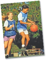 Photograph of two teen girls playing basketball