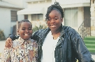 Photograph of a woman with her arm around a boy (a brother perhaps)