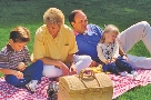 Photograph of four people at a picnic, two adults and two children