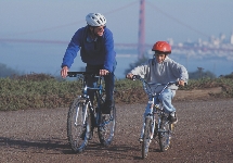 A boy and his father ride bikes near San Francisco, California.