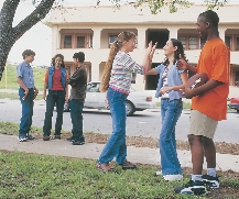 Photograph of two groups of small students talking after school