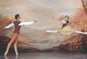 Photograph of two ballet dancers: the woman jumping and the man standing