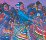 Photograph of several dancers in colorful, traditional dress dancing