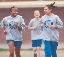 Photograph of three students running in a gym