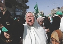 Photograph of a woman in a crowd shouting and looking angry