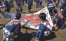 Photograph of a group of people about to fly a gigantic kite