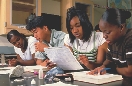 Photograph of several students studying rocks in class