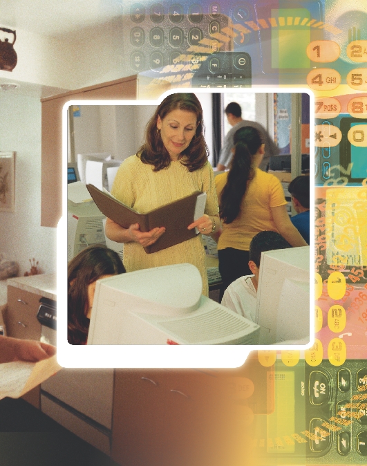 photograph of a female teacher and students in a classroom working on computers