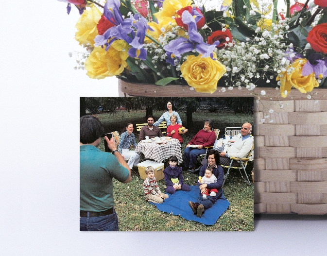 photograph of a family seated on lawn and in chairs in a park-like setting