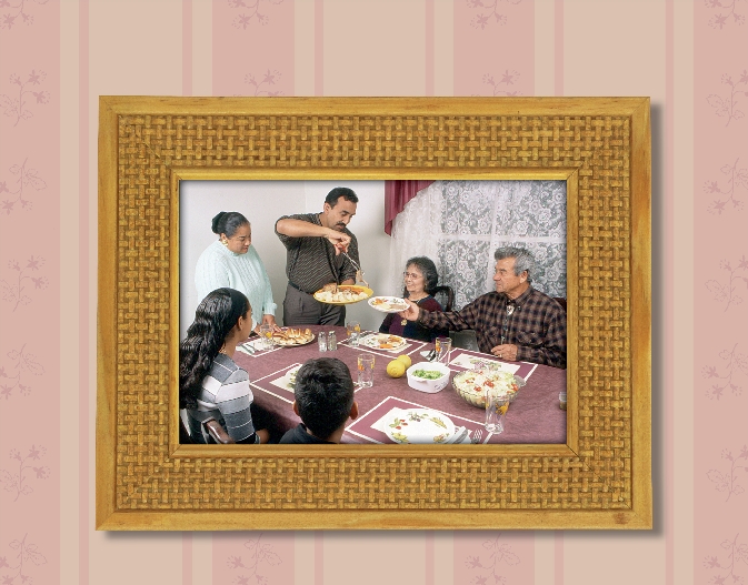 framed photograph of a family seated at a dinner table eating dinner