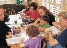 photograph of a family sitting around a table doing homework