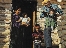 photograph of Native American family standing in front of their home