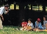 photograph of a man taking a picture of his family in a park