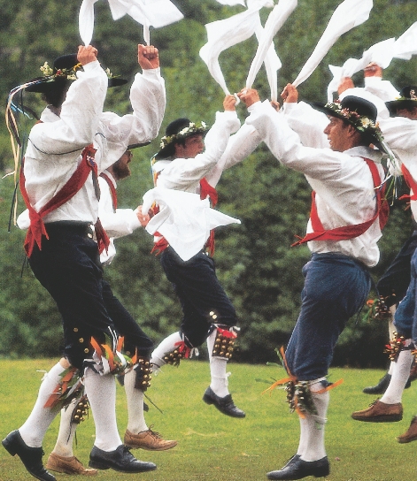 photograph of several young men in traditional English costume, dancing in a park