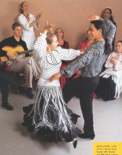 photograph of a man and woman flamenco dancing with guitarists and people watching