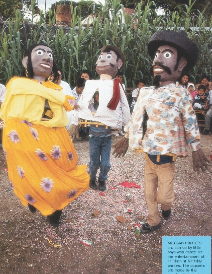 photograph of three people dancing, dressed up in Mexican puppet costumes