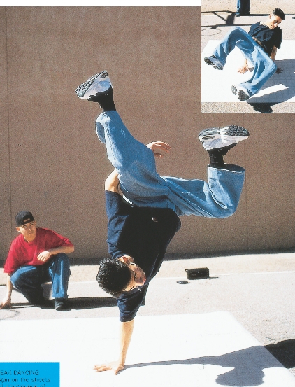 photograph of two teenage boys break-dancing on a sidewalk