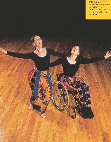 photograph of two women dancing, one is in a wheelchair