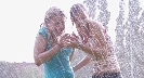 Photograph of two teenage girls getting wet from a heavy rain