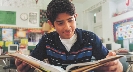 Photograph of a teenage boy reading a book