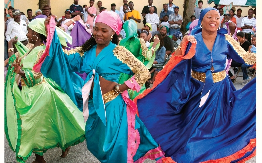 Thousands of Haitians moved to Miami, Florida, in the 1980s. They formed a neighborhood called Little Haiti. Dancers move to the music at a street market.