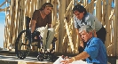 Photograph of three people looking at a large piece of paper.