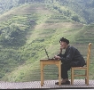 A man who lives in the mountains in China uses his computer.