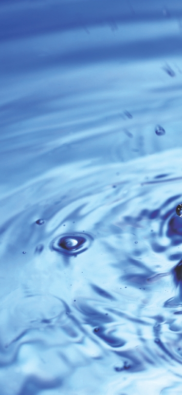 Photograph of close up of a drop of water hitting the surface of water and splashing back up