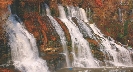 Photograph of water from a river spilling down over a wall of rock