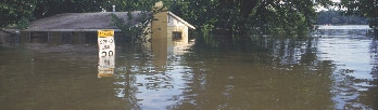 Photograph of a house sitting in water from a flood