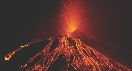 Photograph of red-hot lava thrown into air and flowing down the sides of a volcano