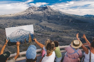 Visitors compare an old photo of Mount St. Helens to the volcano today.