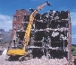 Photograph of a crane destroying a building