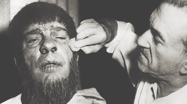 Lon Chaney, Jr., plays the Wolf Man. Jack Pierce puts makeup on the actor’s face.