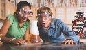 Photograph of two children watching a chemical reaction in a flask, looking excited