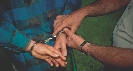 Photograph of a person being handcuffed